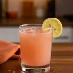 Pink Salt Trick Recipe for Morning Detox and Energy 2 Glass of pink salt trick recipe served with lemon slice on wooden counter